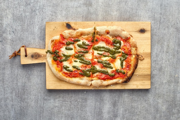 Focaccia o pizza recién horneada con mozzarella y pesto