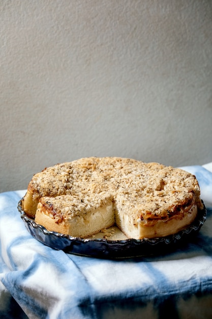 Focaccia siciliana branca. bolo de pão tradicional fatiado com cebola, ervas e queijo em prato de cerâmica servido sobre toalha de mesa azul e branca.