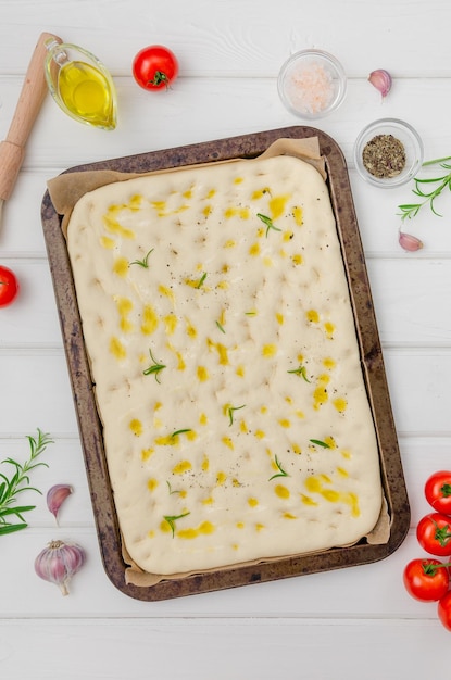 Focaccia tradicional italiana sin hornear con sal marina de ajo romero y aceite de oliva Vista superior