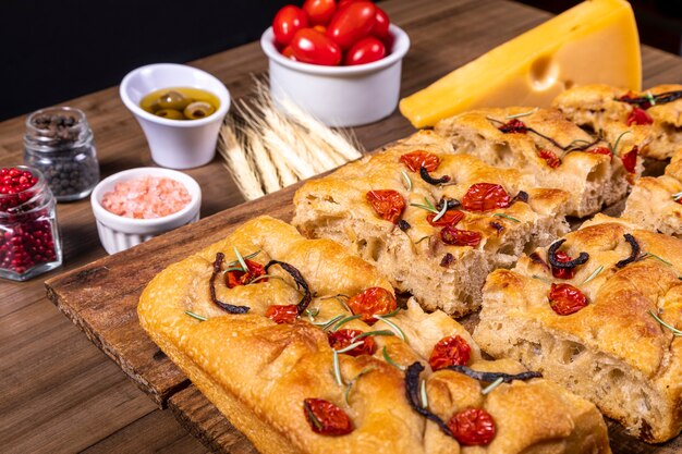 Focaccia tradicional italiana con tomates cherry, aceitunas negras y romero