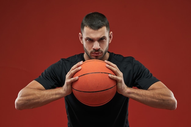 Focado seriamente masculino em camisa preta olhando e posando para a câmera fotográfica