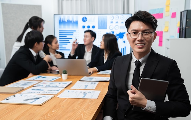 Focalize o gerente masculino do retrato no escritório da harmonia com os empresários no fundo