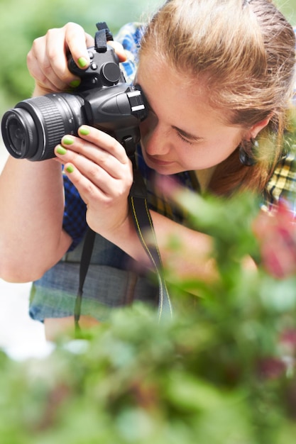 Focando na fotografia da natureza Uma linda jovem focando através da lente de sua câmera