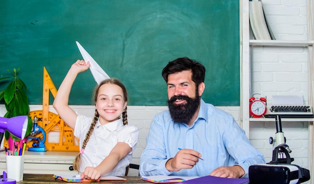 Focando no trabalho de volta à escola Ensino particular menina pequena com professor barbudo homem no dia do conhecimento em sala de aula Ensino em casa aula particular filha estudo com pai Dia dos professores