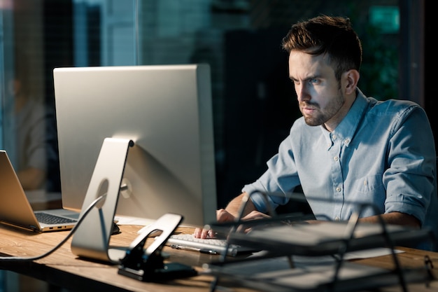 Focando o homem que trabalha com o computador no escritório