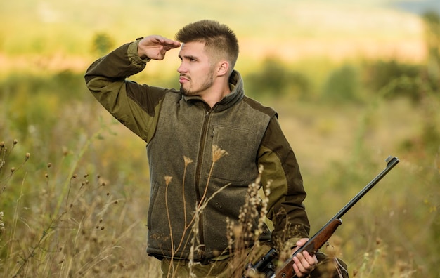 Foco e concentração de caçador experiente Tempadas de caça e armadilhas Homem guarda-caça brutal origem da natureza Permissão de caça Caçador barbudo passar o tempo livre caçando Caçador segurar rifle