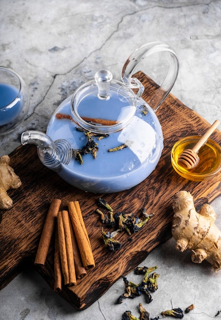 Foto foco seletivo chá de masala azul acabado de fazer em um bule de chá transparente com frutas e bagas frescas ...