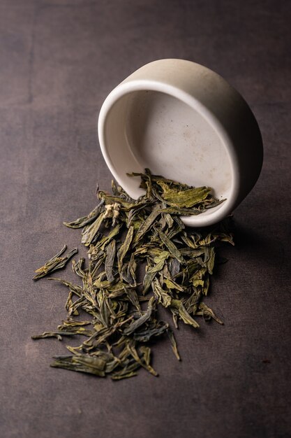 Foco seletivo, chá verde natural, fermentando em uma macro de ângulo vertical de tigela de argila em um fundo de luz.