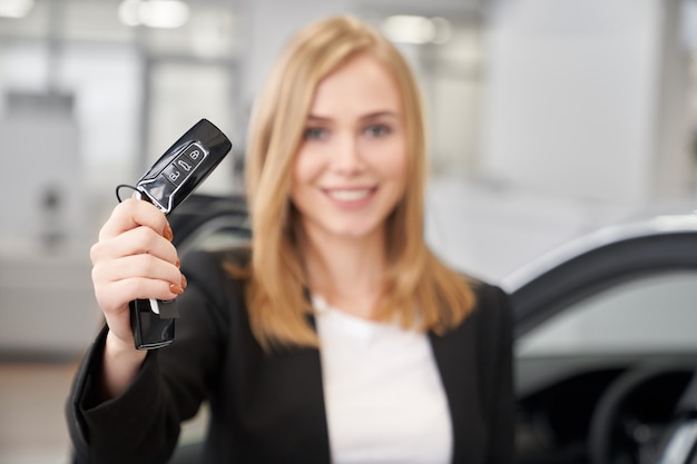 Foto foco seletivo das chaves do carro nas mãos do negociante de carro feminino