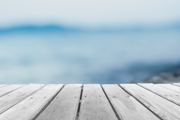 Foco seletivo de mesa de madeira velha com fundo de praia bonito para exibir seu produto.