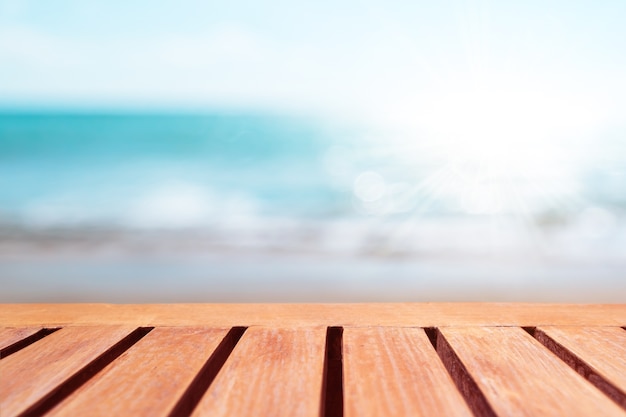 Foco seletivo de mesa de madeira velha com fundo de praia bonito para exibir seu produto.