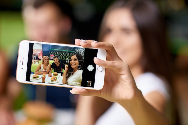 Foco seletivo do telefone tendo selfie de amigos