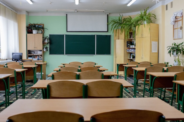 Foco seletivo macio e desfoque. cadeiras de leitura de fileira de madeira velha na sala de aula na escola pobre. sala de estudo sem aluno. conceito de educação