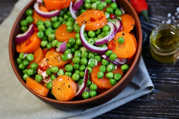 Foco seletivo Macro Saudável tigela de salada com ervilhas verdes, cenouras e cebolas azuis Comida dietética Salada fitness