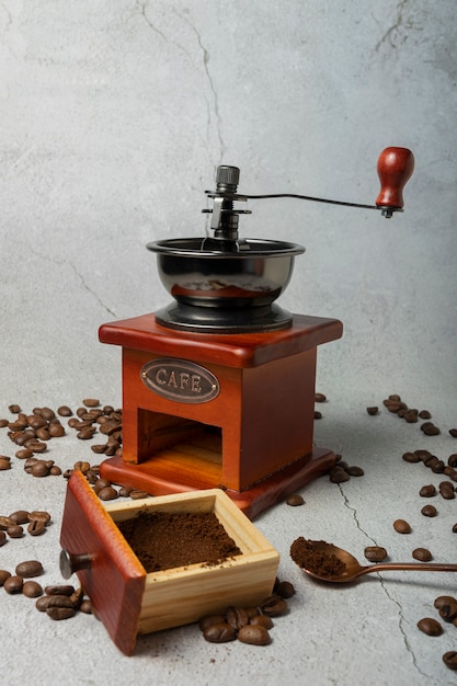 Foco seletivo. moinho de café retro manual. madeira escura sobre um fundo cinza claro. com Café escrito em letras de metal