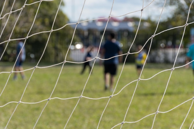 Foco seletivo na rede de um gol de futebol e jogo de chão