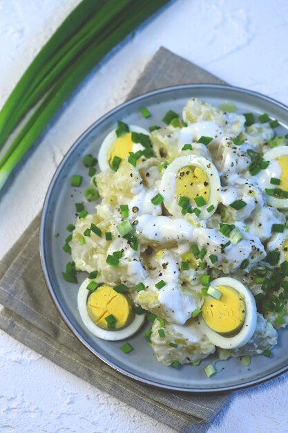 Foco seletivo Salada de batata saudável com ovo de molho de iogurte e cebola verde Salada vegetariana