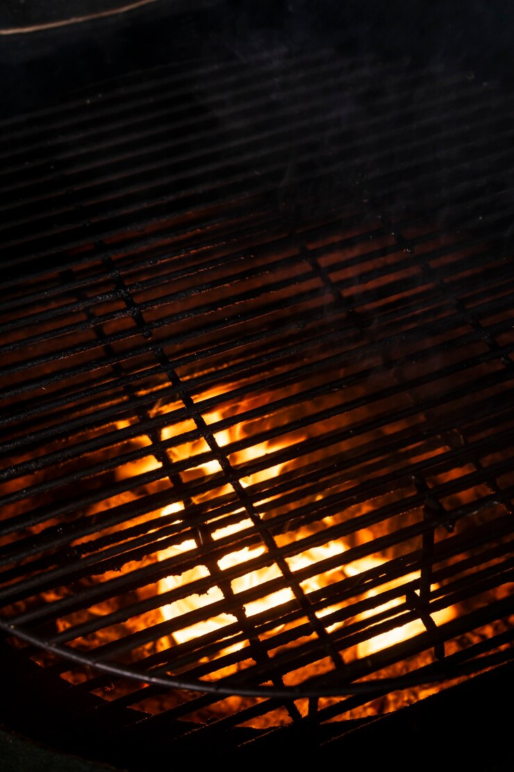 Foto foco seletivo, textura de fogo, grelha com carvão em brasa. fundo para menus e anúncios