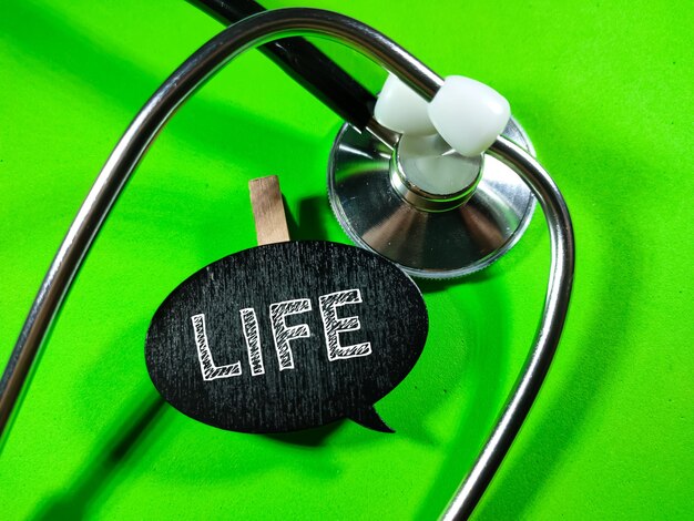 Foco seletivoWord LIFE em fundo verde com estetoscópioConceito médico