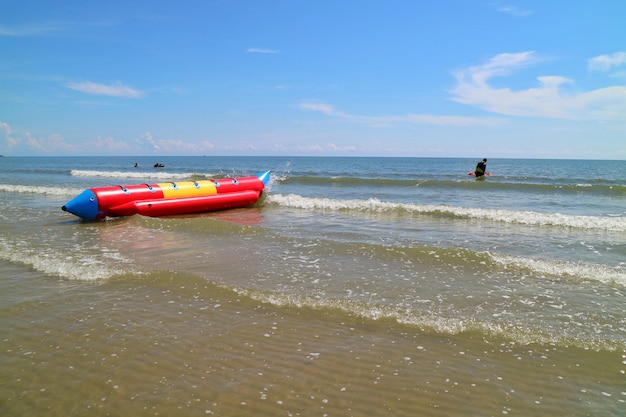 Foco suave de bela vista das ondas na praia com banana boat e céu azul