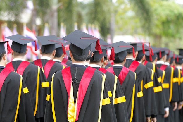 foco suave e embaçada de formandos estão andando na linha para obter um diploma