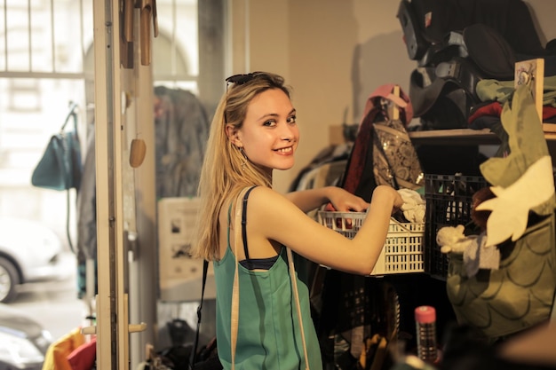 Foco superficial de una joven rubia sonriendo en una tienda de segunda mano vintage