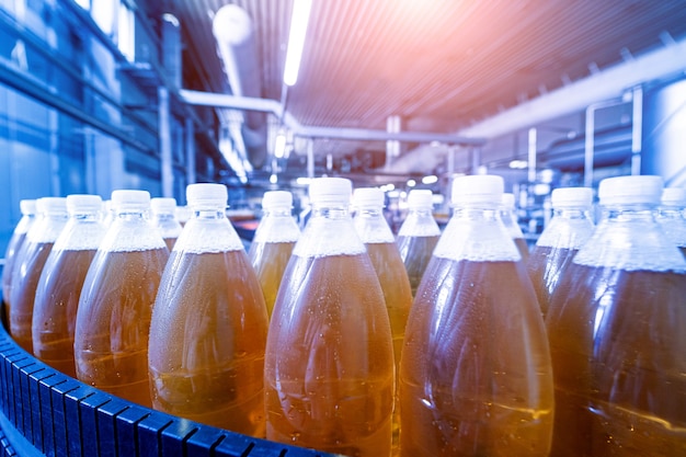 Förderband mit Flaschen für Saft oder Wasser in einer modernen Getränkefabrik