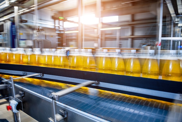 Förderband mit Flaschen für Saft oder Wasser in einer modernen Getränkefabrik