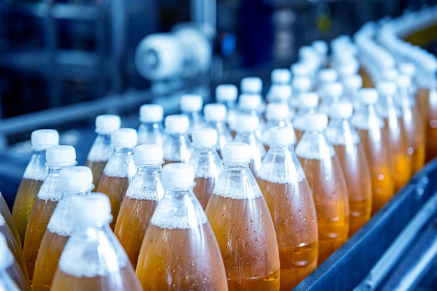 Förderband mit Flaschen für Saft oder Wasser in einer modernen Getränkefabrik
