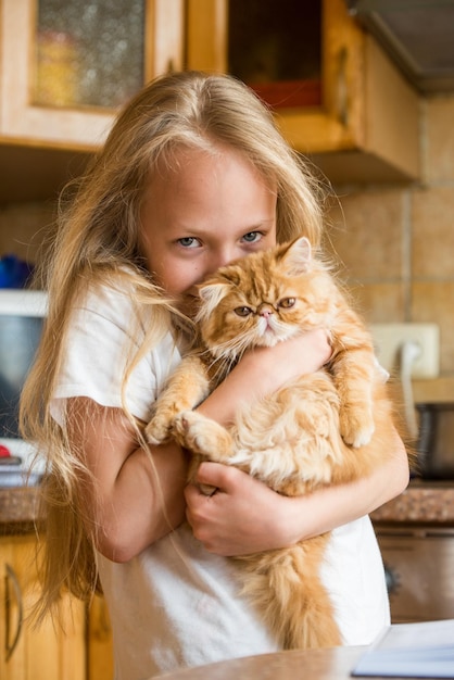 Fofinho gatinho persa doméstico em meninas entregando gato e criança em casa