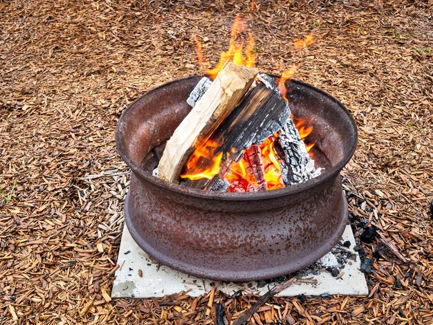 Fogo de acampamento em uma roda de aço na base de concreto