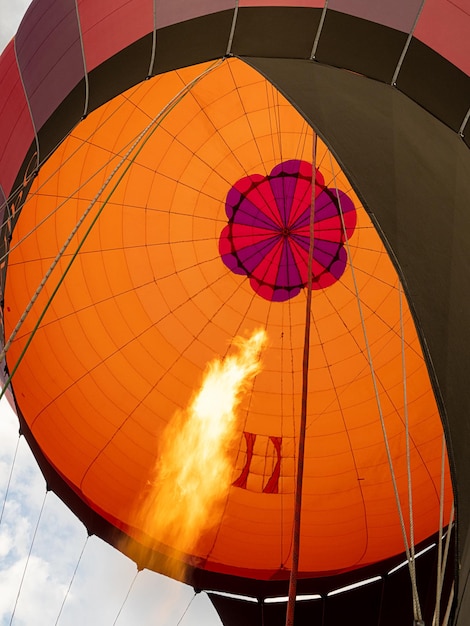 Fogo do queimador de gás com propano infla grande balão de ar quente colorido antes de voar.