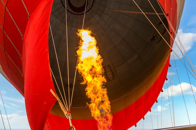 Fogo em balão de ar quente em um fundo de céu azul fechado