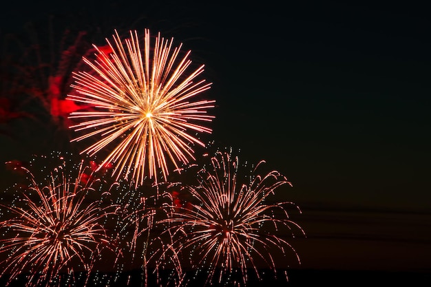 Fogos de artifício coloridos brilhantes em uma noite festiva Explosões de fogo colorido no céu
