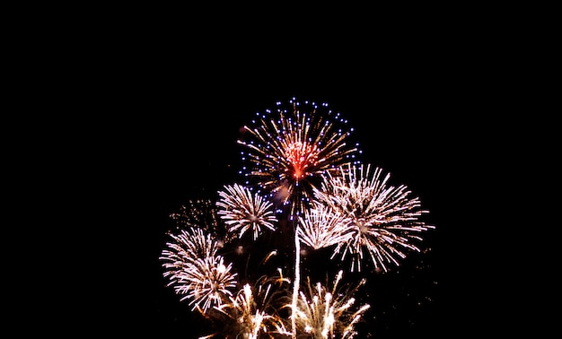 Fogos de artifício coloridos no céu noturno com brilho