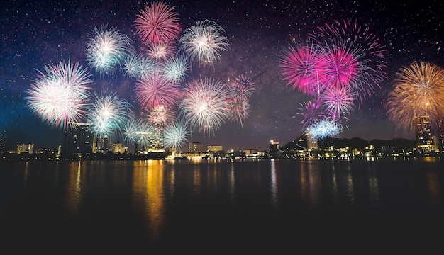 Fogos de artifício coloridos sobre a cidade na praia Celebração de fogos de artifício brilhando no céu da meia-noite