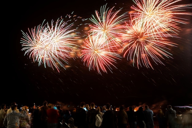 Fogos de artifício com silhuetas de pessoas em eventos de férias