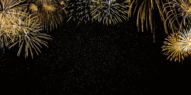 Foto fogos de artifício dourados no fundo do céu negro com estrelas comemoração do ano novo e aniversário