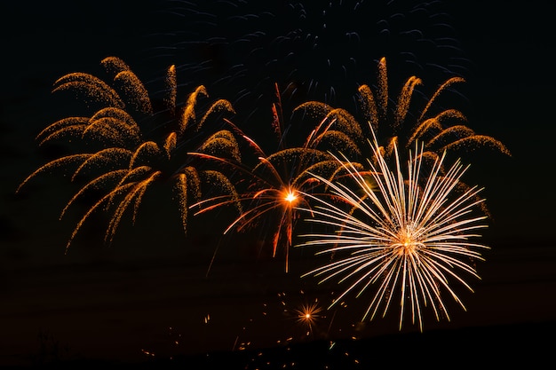 Foto fogos de artifício festivos no céu noturno. saudação multicolorida brilhante em um espaço preto. lugar para texto.