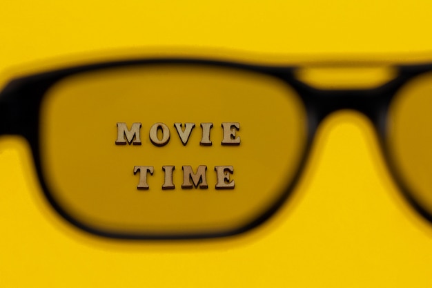 Fokus auf Text Filmzeit durch Brille 3D auf gelbem Papierhintergrund.