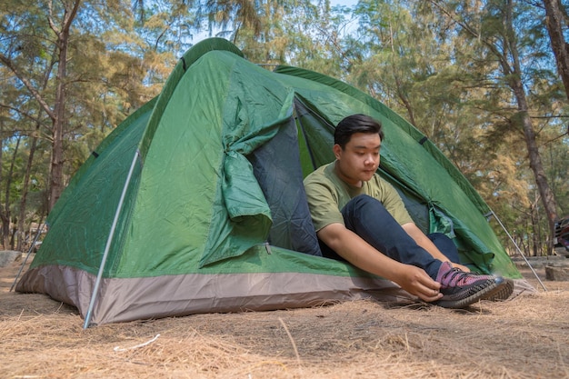 Fokus-Pfadfinder stellt ein Zelt im Wald auf. Camp im Zelt Tourist, der ein Zelt auf dem Campingplatz aufstellt