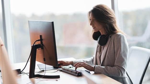 Fokussierte Geschäftsfrau, die am Arbeitsplatz in einem modernen Büro am Computer arbeitet