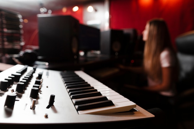 Foto fokussierte tastatur und unscharfe frau im studio