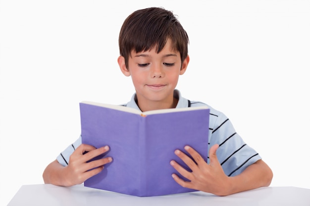 Fokussierter Junge, der ein Buch liest