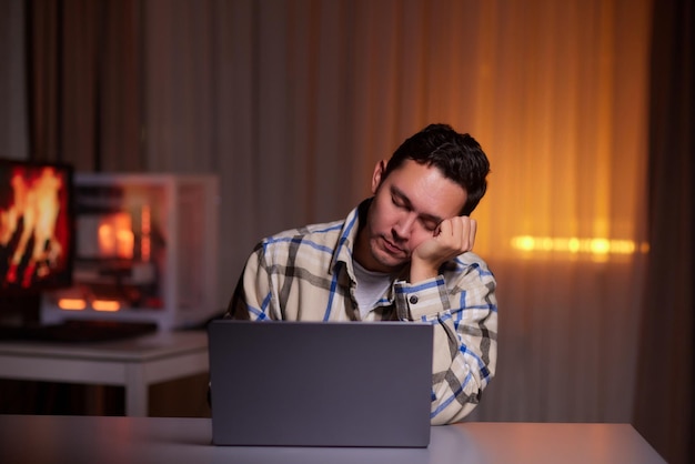 Fokussierter junger Mann mit Brille, der mit einem Laptop auf der Tastatur schreibt