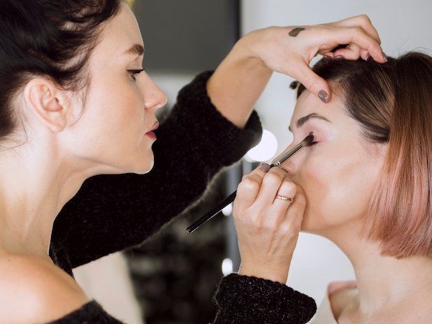 Fokussierter Künstler, der Make-up tut