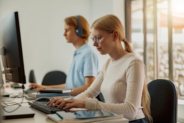 Fokussierter Universitätsstudent, der Computer im Computerraum studiert