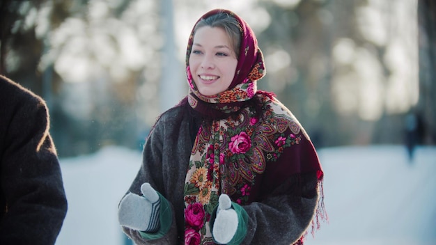 Folclore ruso hermosa mujer rusa en una bufanda está aplaudiendo