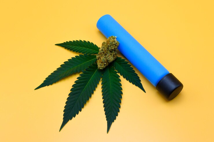 Foto folha de cannabis fresca verde com botões de flores secas e tampa de parafuso de tubo de ensaio azul em fundo isolado amarelo folha de maconha verde fresca e botões em fundo laranja studio shot