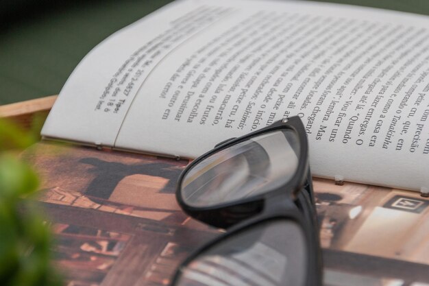 Folha de livro com óculos em cima de mesa no Rio de Janeiro